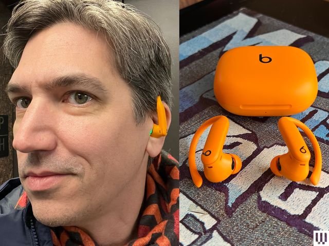 Person wearing beats Powerbeats Pro 2 earbuds in bright orange with charging case
