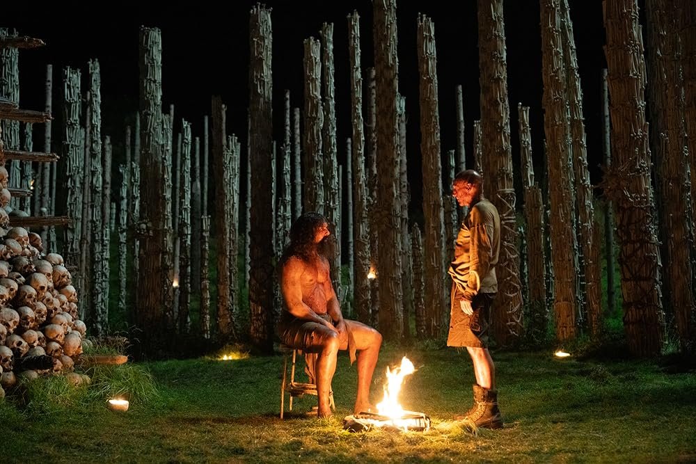 Samson seated beside Dr Kelson surrounded by bones