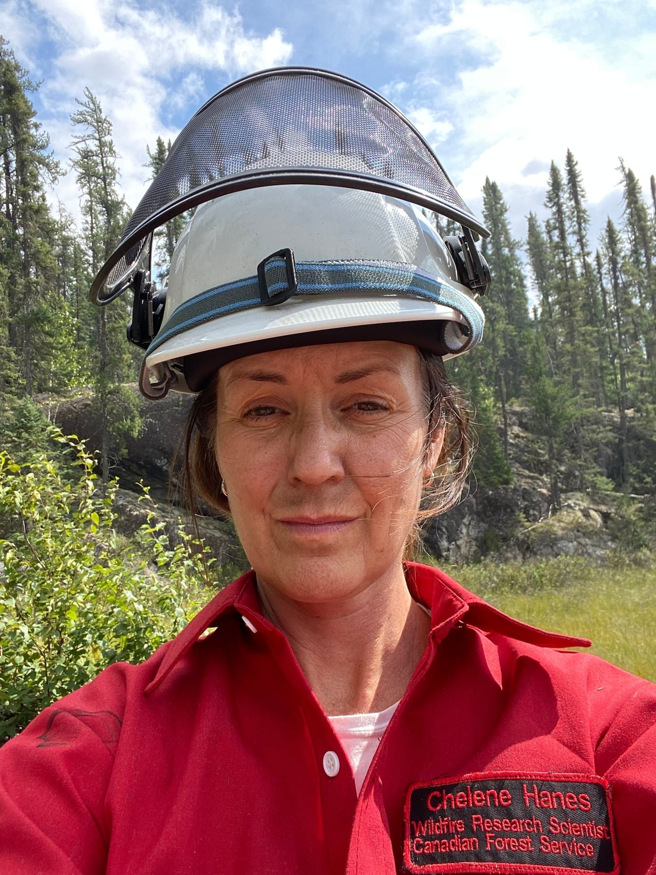 Forest firefighter wearing helmet amidst trees