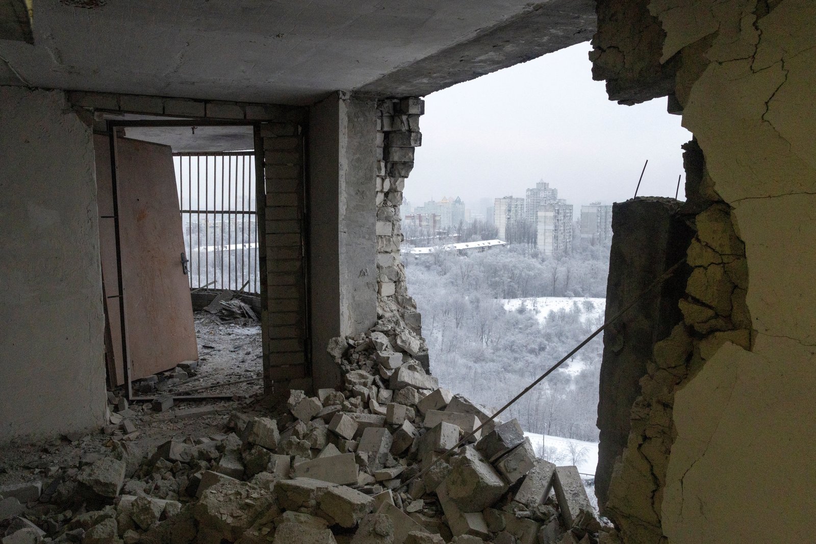 Winter view of Kyiv through damage caused by a Russian drone strike on an apartment building
