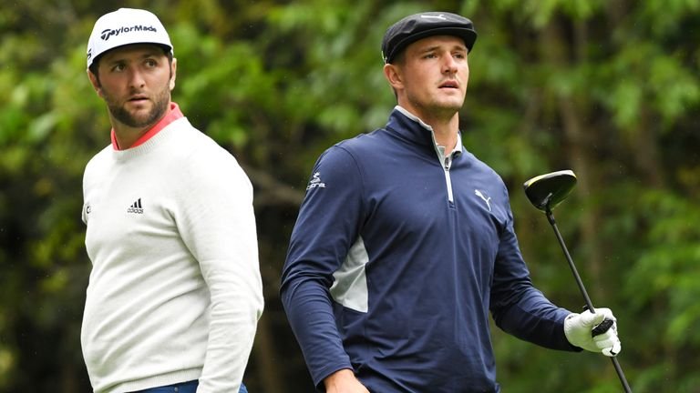 Jon Rahm (left) and Bryson DeChambeau watching tournament play