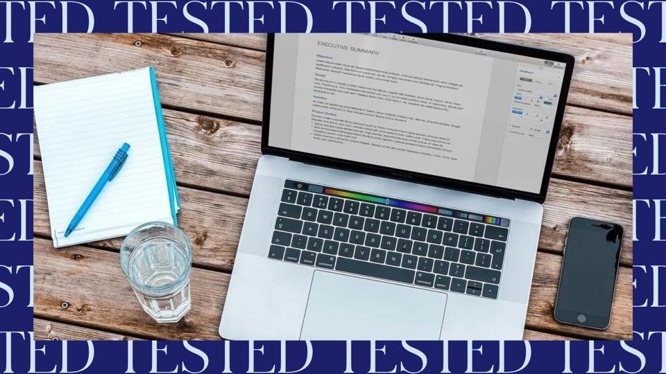 Workspace with computer, phone, and notepad on blue background labeled 'tested'