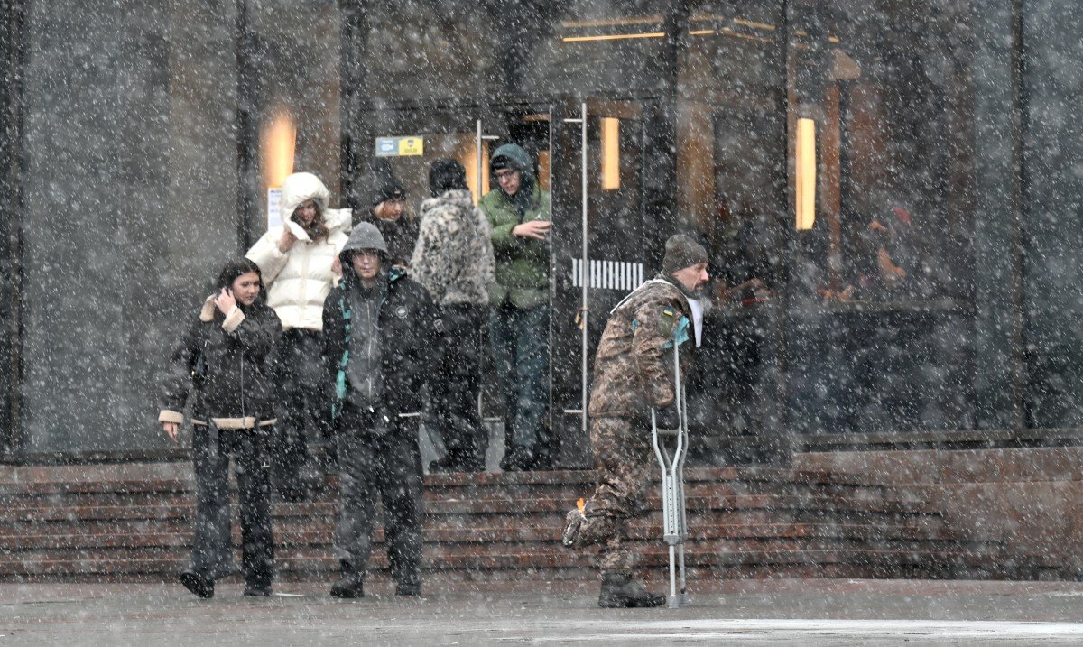 Injured Ukrainian soldier walking through snowy street in Kyiv