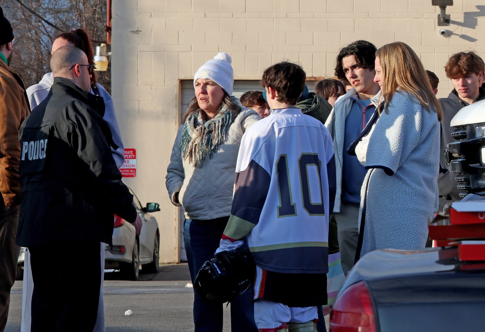 Police officer speaking with high school hockey players near Lynch Arena after shooting
