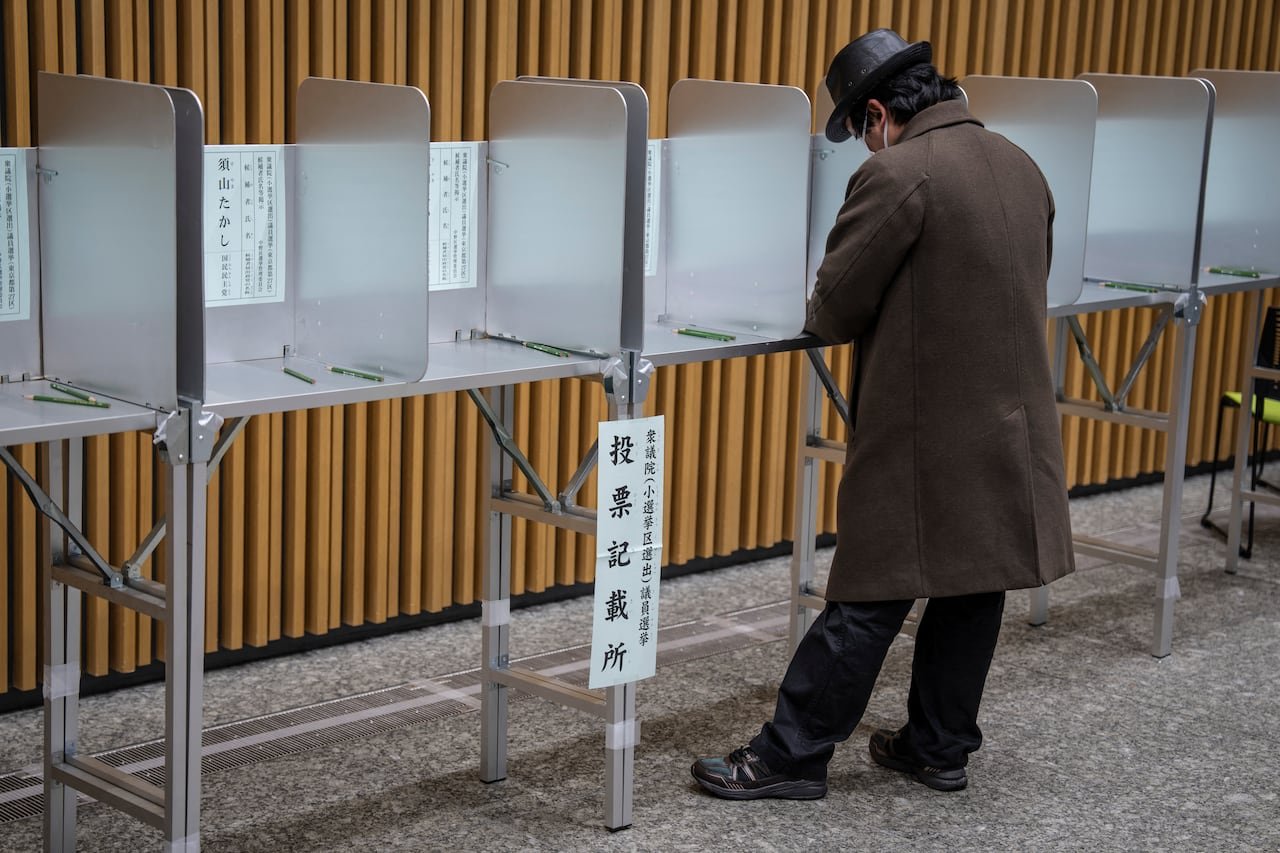 A voter fills out a ballot at a polling station.