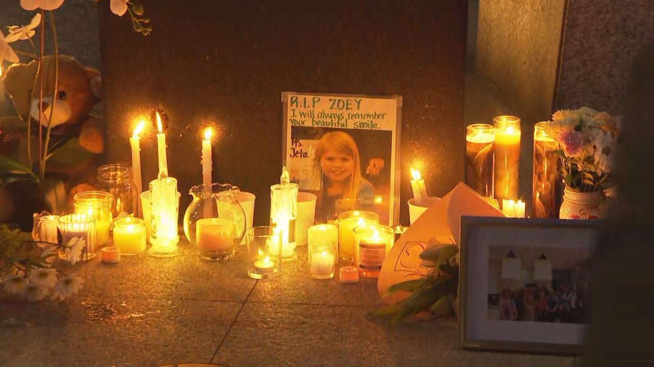 Candles and flowers surround photo memorial for young victim at Langley vigil