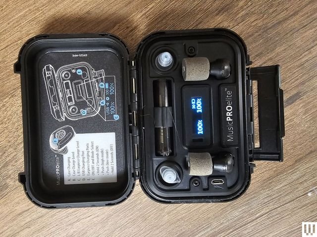Open small black case showing rechargeable earbuds with digital display