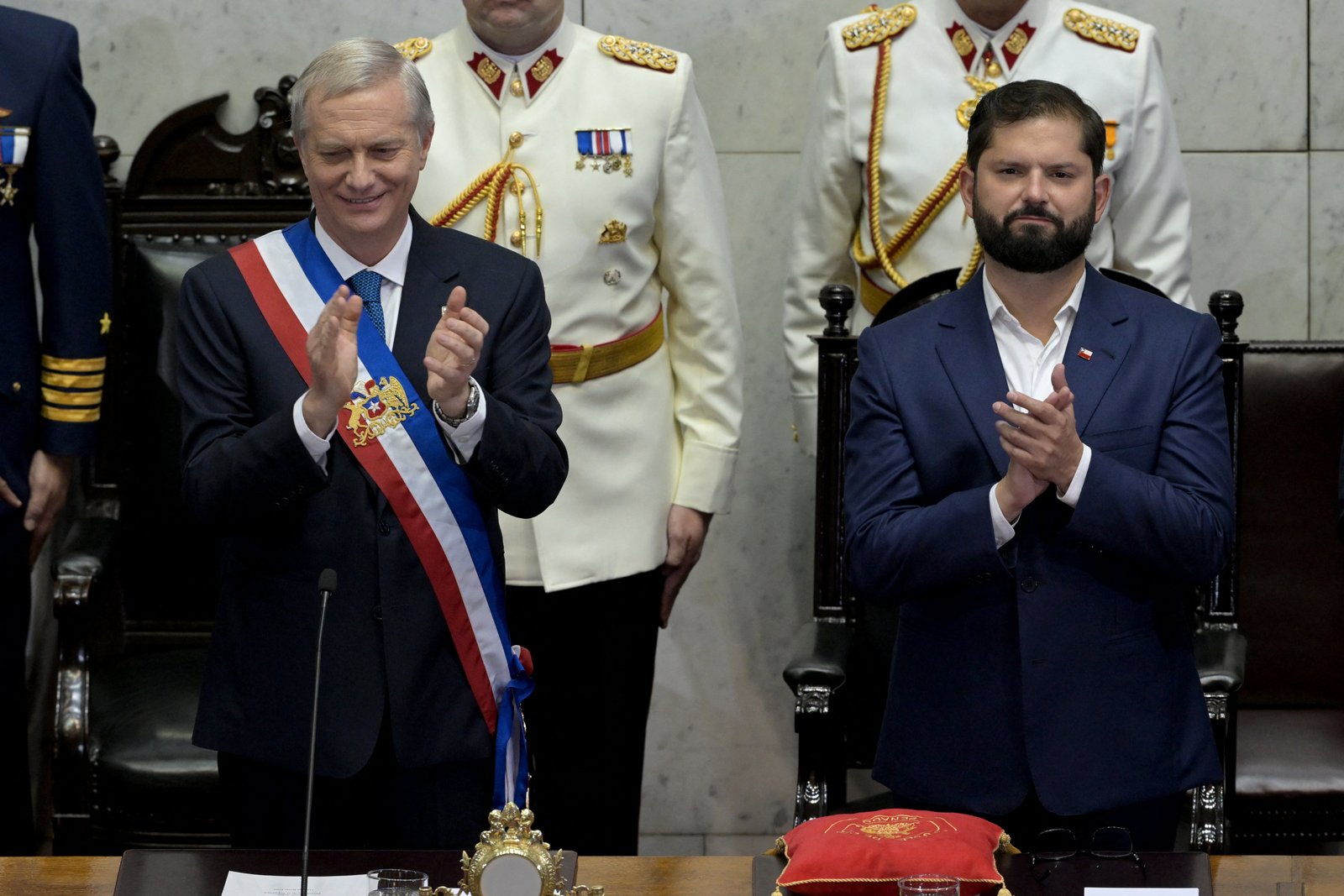 Jose Antonio Kast standing beside outgoing president Gabriel Boric during inauguration ceremony