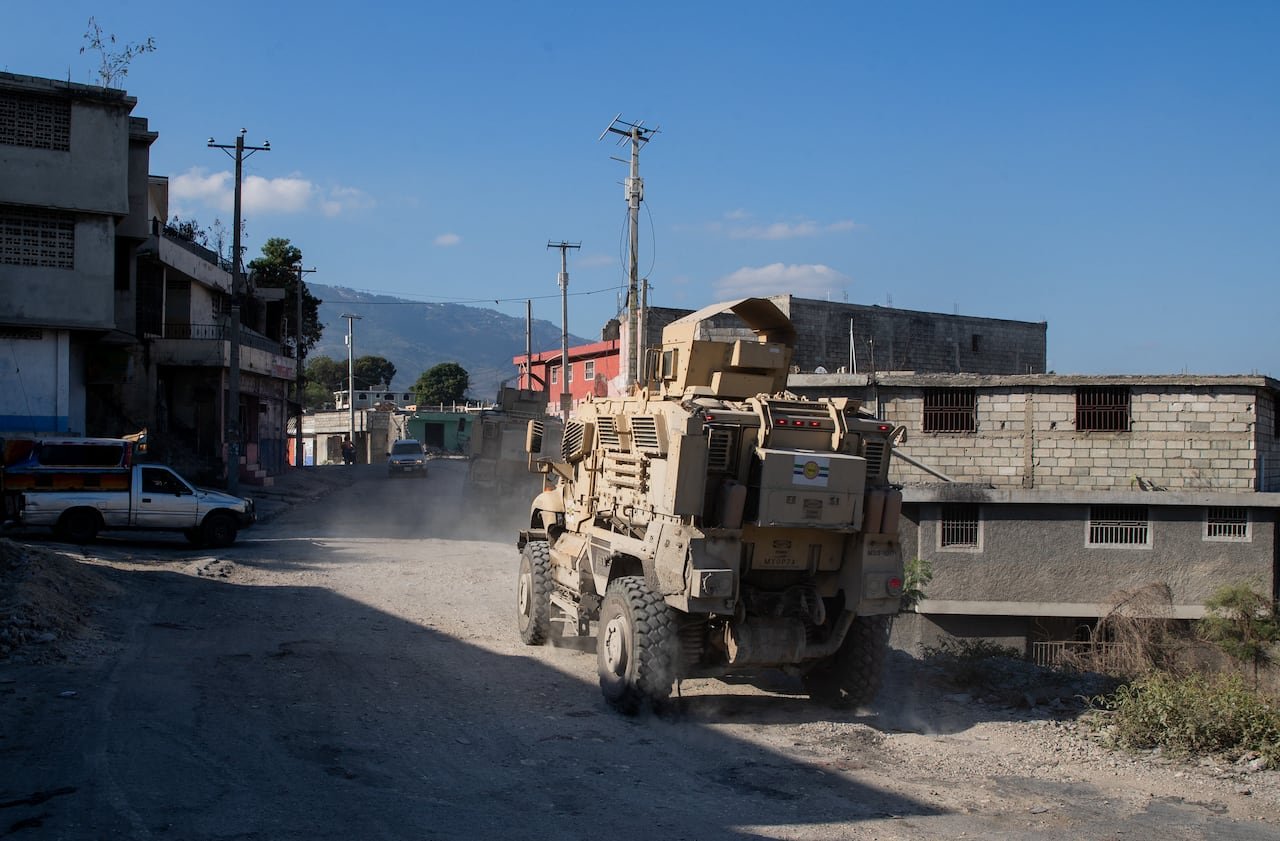 Armored police vehicle patrolling a neighborhood street in Port-au-Prince