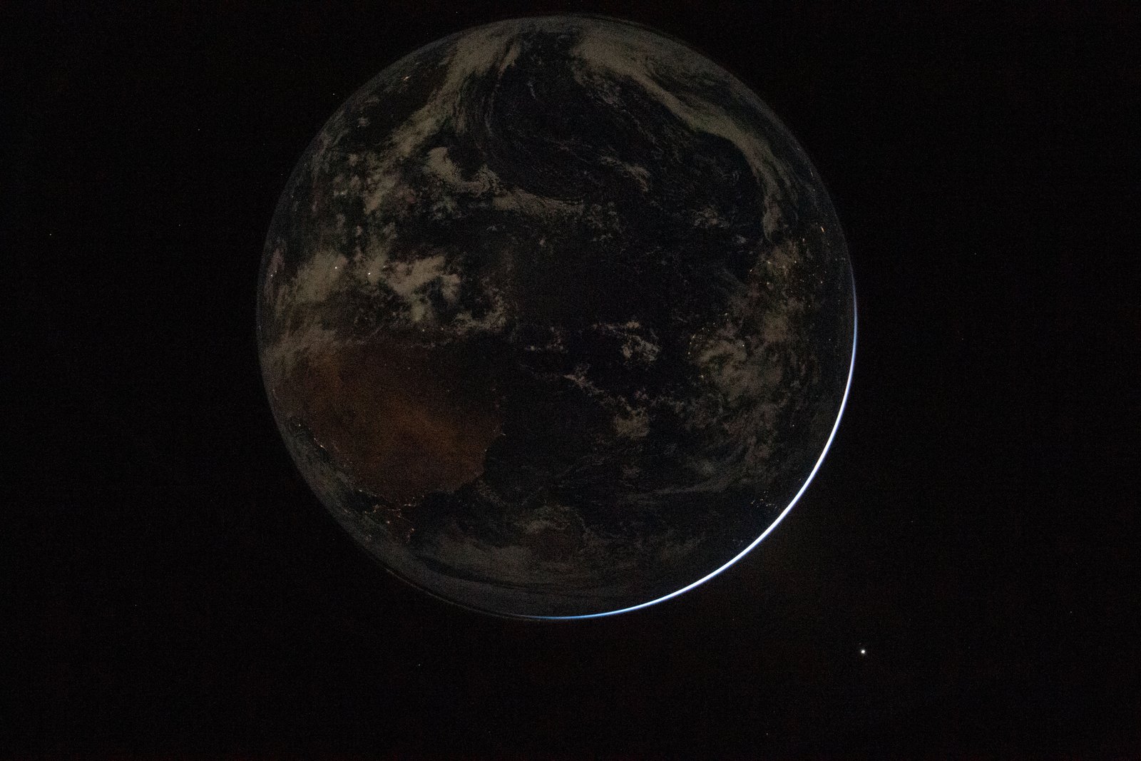 view of backlit Earth through Orion spacecraft window