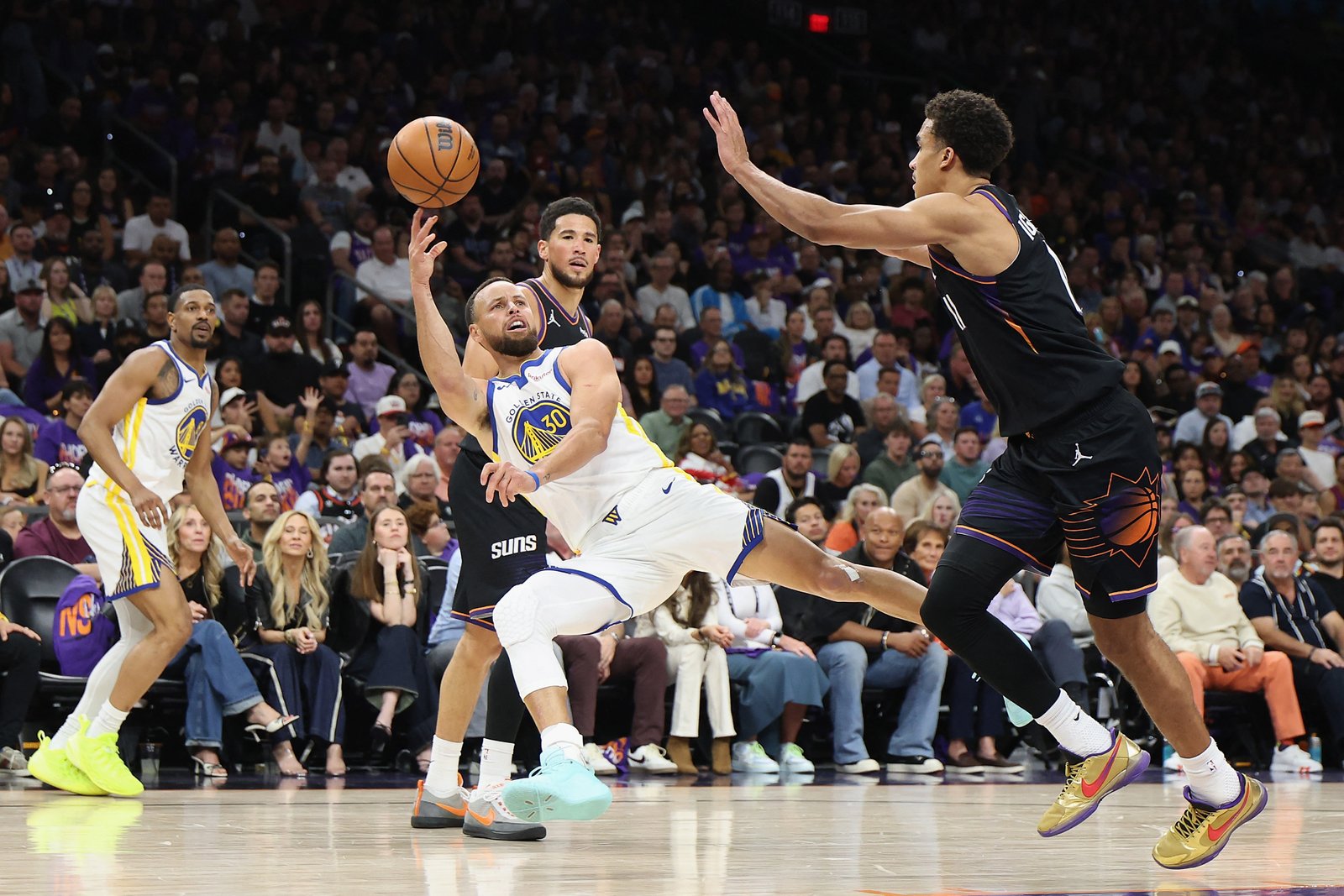 Stephen Curry #30 attempts shot under pressure from Oso Ighodaro #11 of phoenix Suns