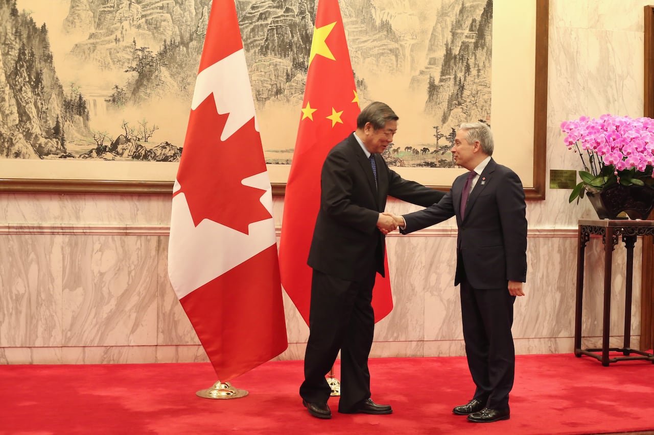 Canadian Finance Minister shaking hands with Chinese official