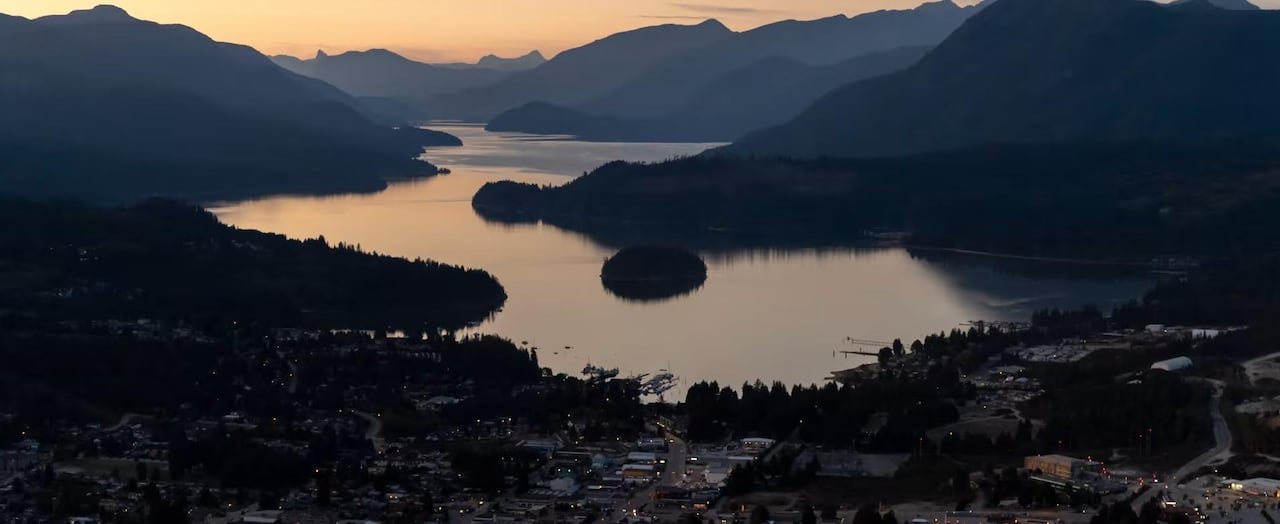Scenic view overlooking residential area surrounded by forested hills in Sechelt