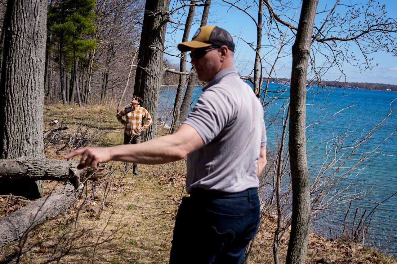 Dave & Sharroll Van Hal standing beside riverbank edge discussing ongoing challenges related to burial site orders.