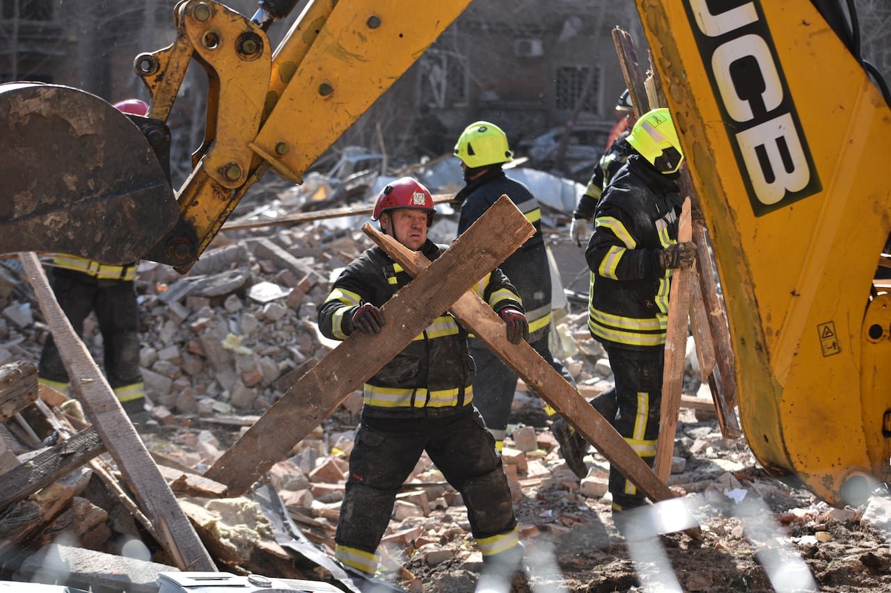 Rescue worker holding rubble at site of destruction in Ukraine