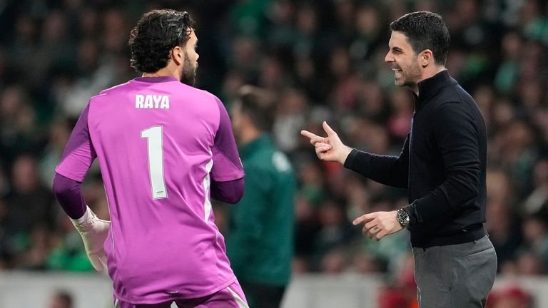 Mikel Arteta discusses tactics with David Raya mid-game at Lisbon stadium