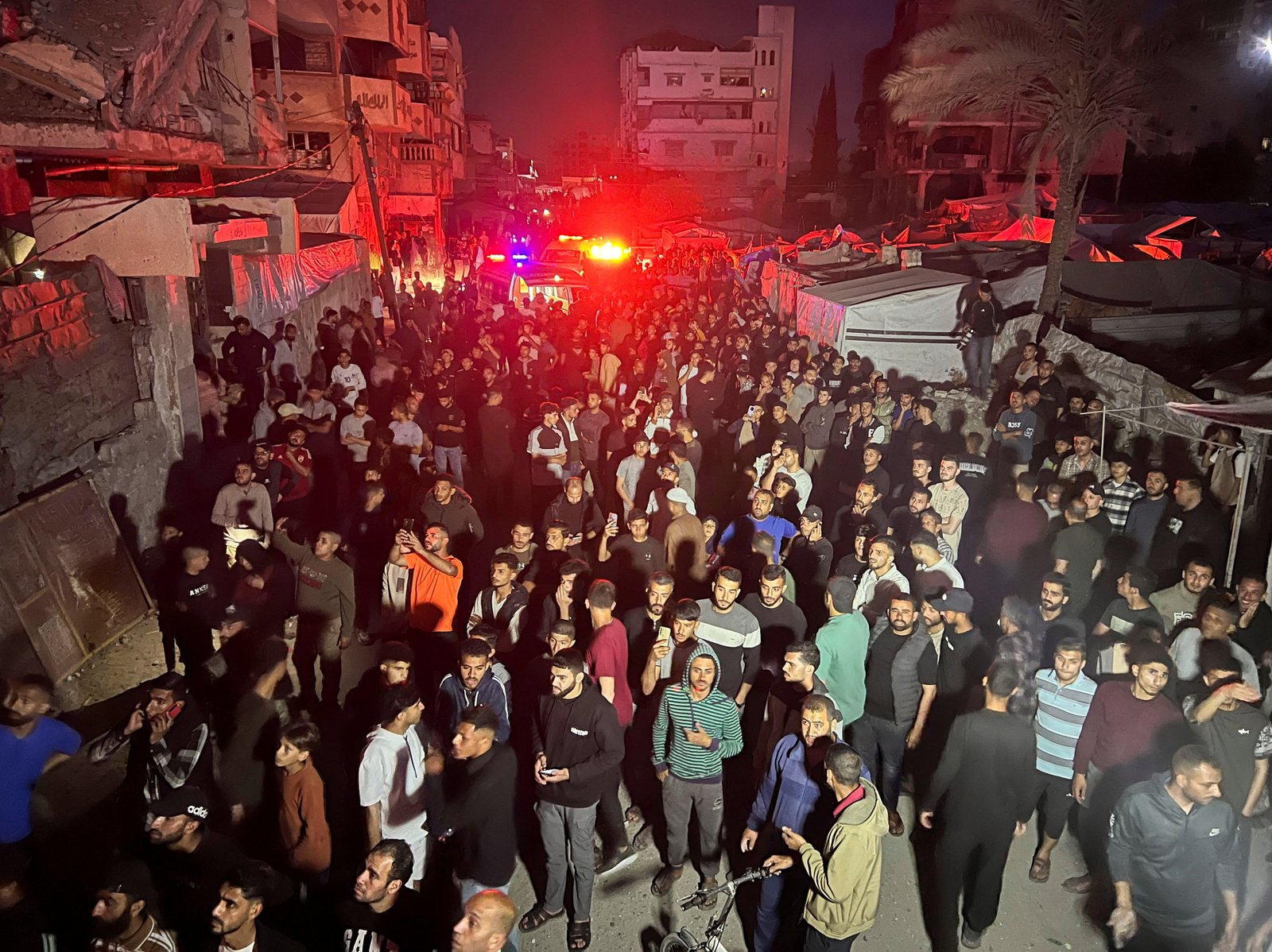 Residents gather near burning apartment after airstrike in Gaza City