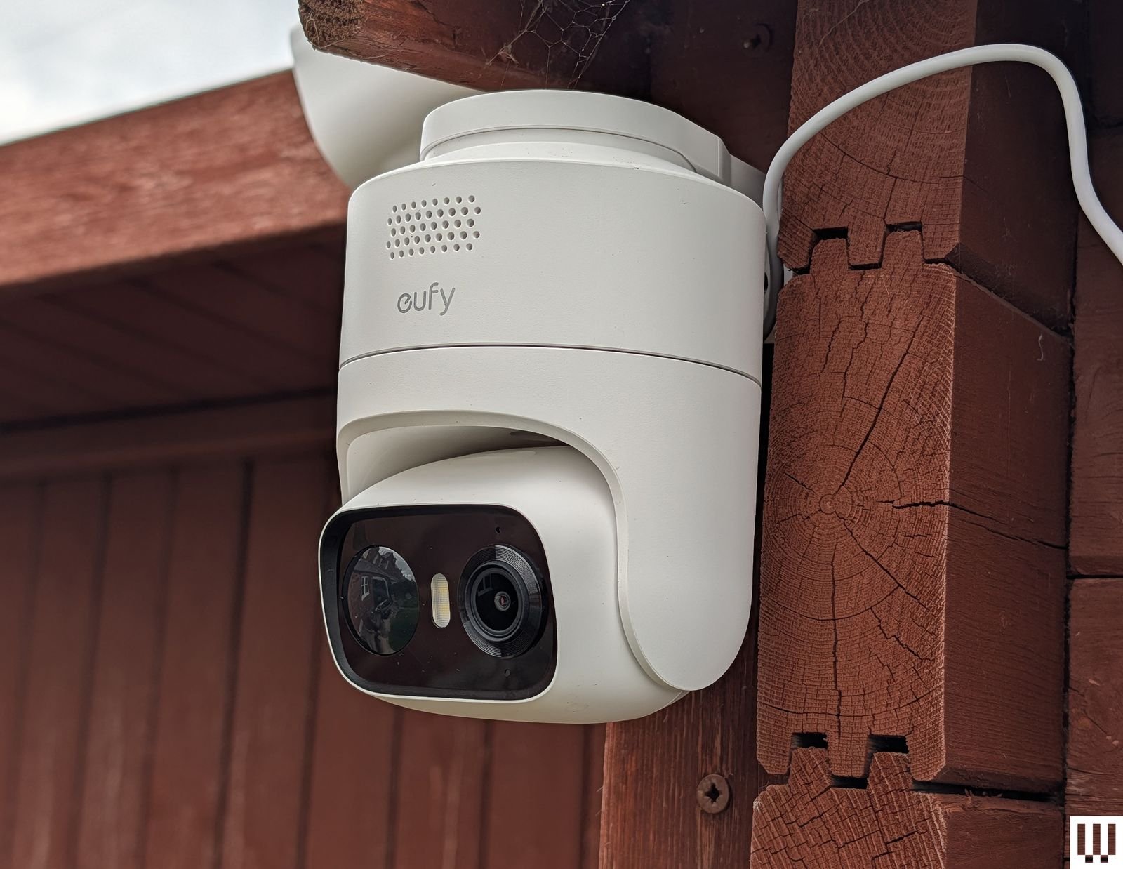 Compact white cylindrical outdoor security camera mounted outside
