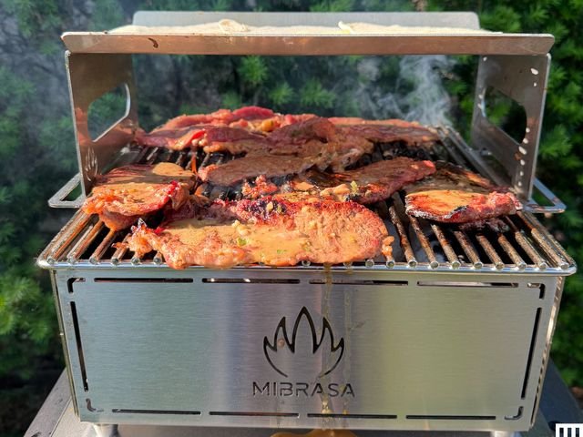 Front view of Mibrasa Hibachi MH 300 PLUS grill cooking meat outdoors