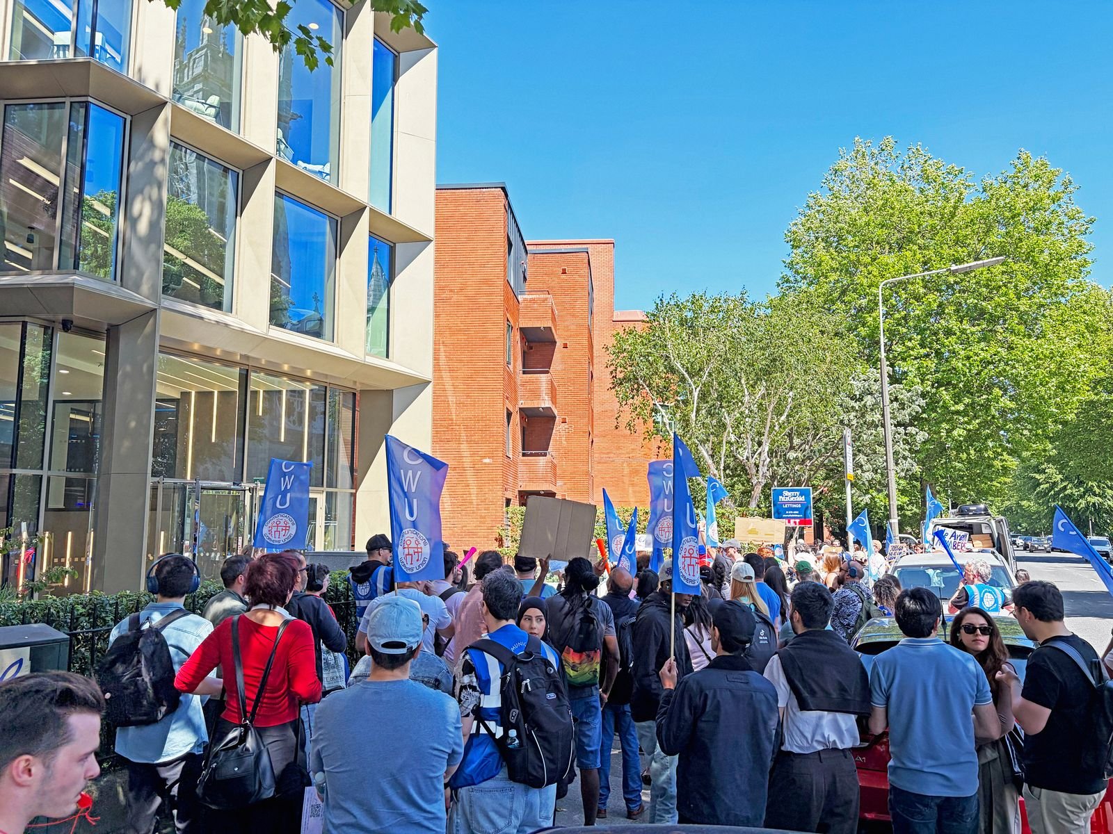 Protesters holding signs outside corporate building