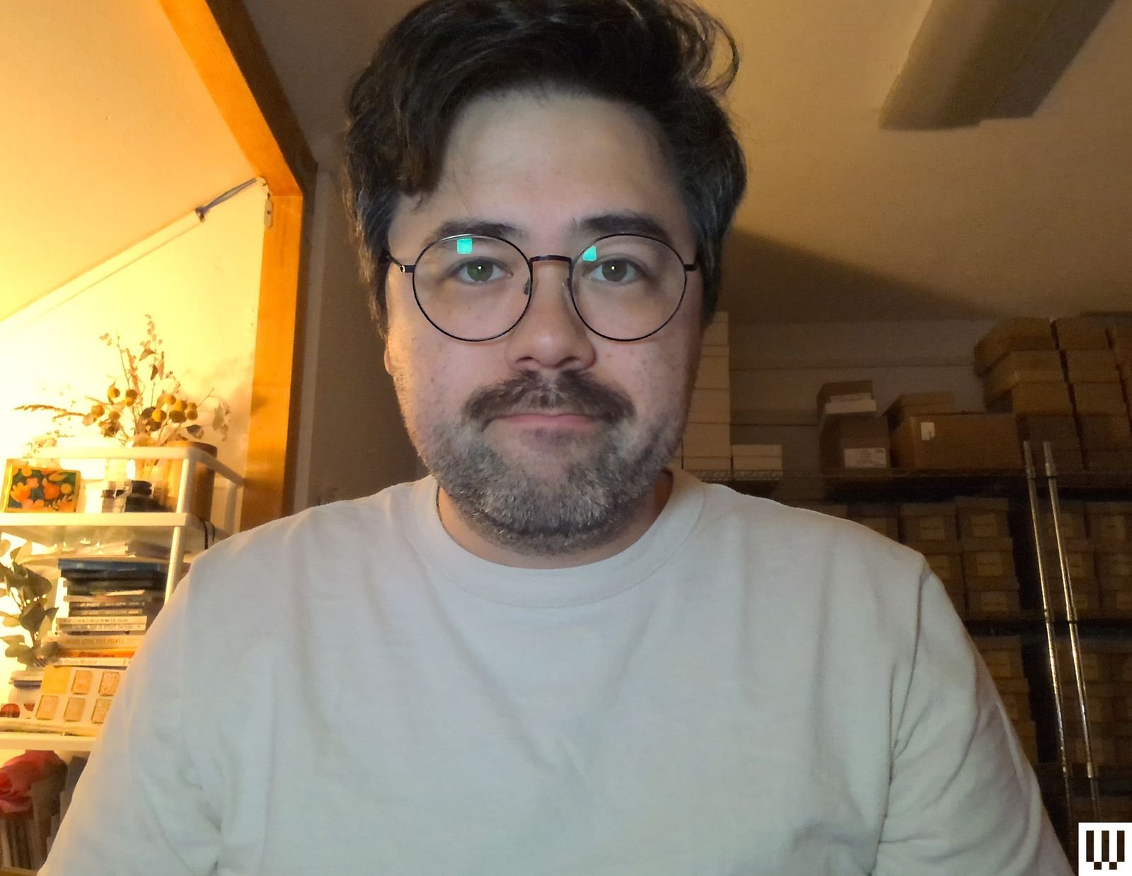 Home office setup featuring person illuminated by small LED clip-on light next to webcam