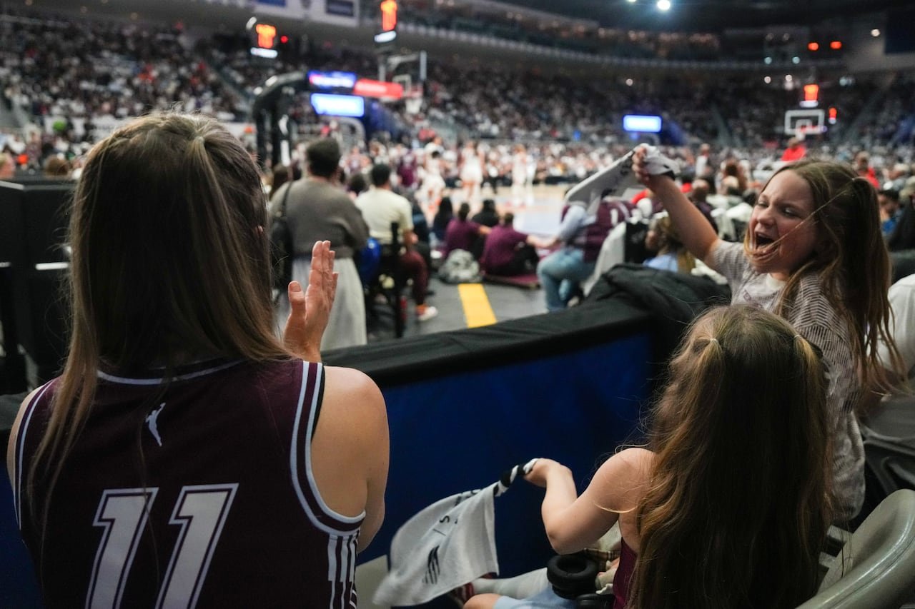 Young fans cheer enthusiastically during basketball game