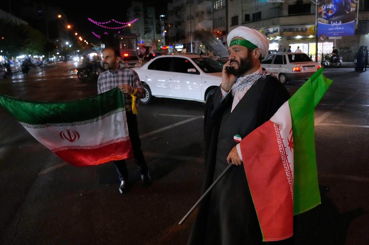 pro-government supporters holding Iranian flags during nighttime rally