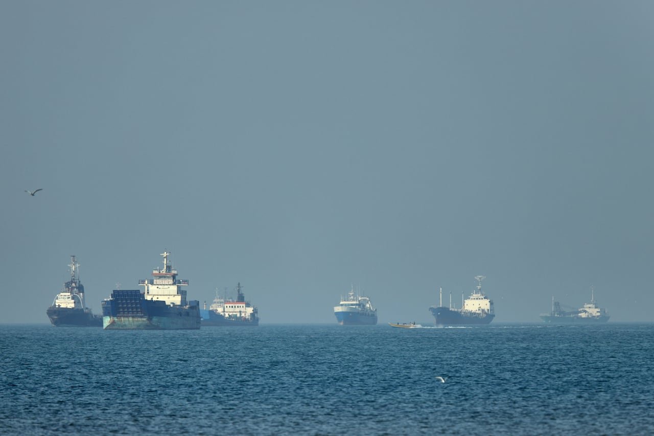cargo ships anchored offshore near Strait of Hormuz