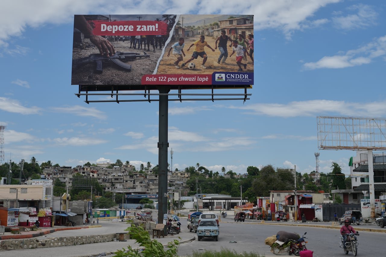 Billboard advocating disarmament on streets controlled by gangs