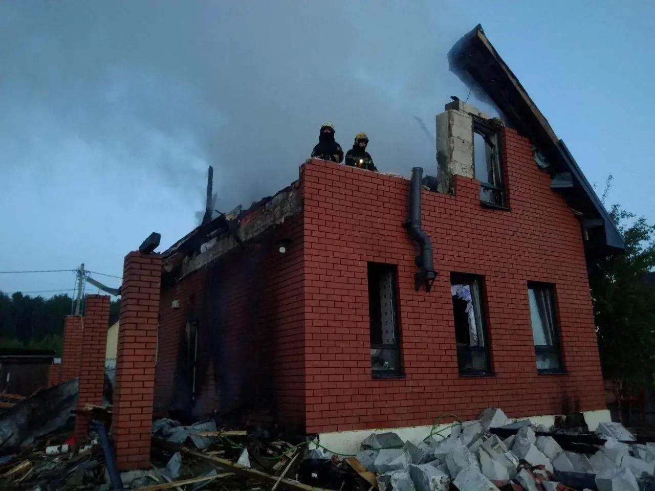 Firefighters inspecting damaged house post missile attack