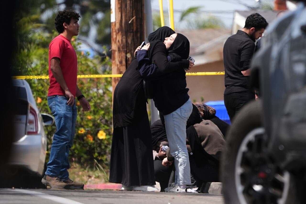 People embracing near cordoned off area