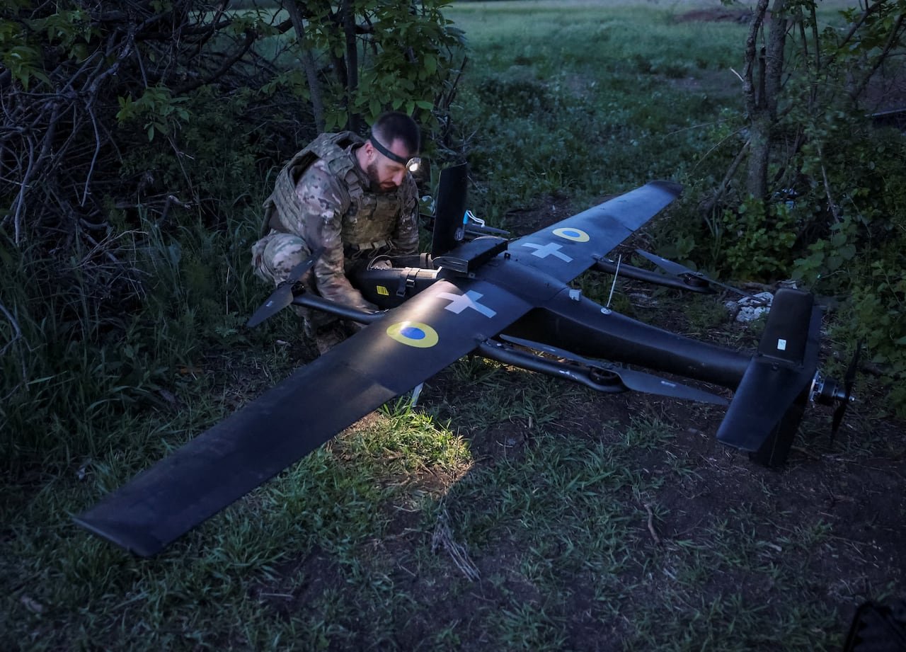 Ukrainian soldier preparing AI-equipped multifunctional UAV near frontline
