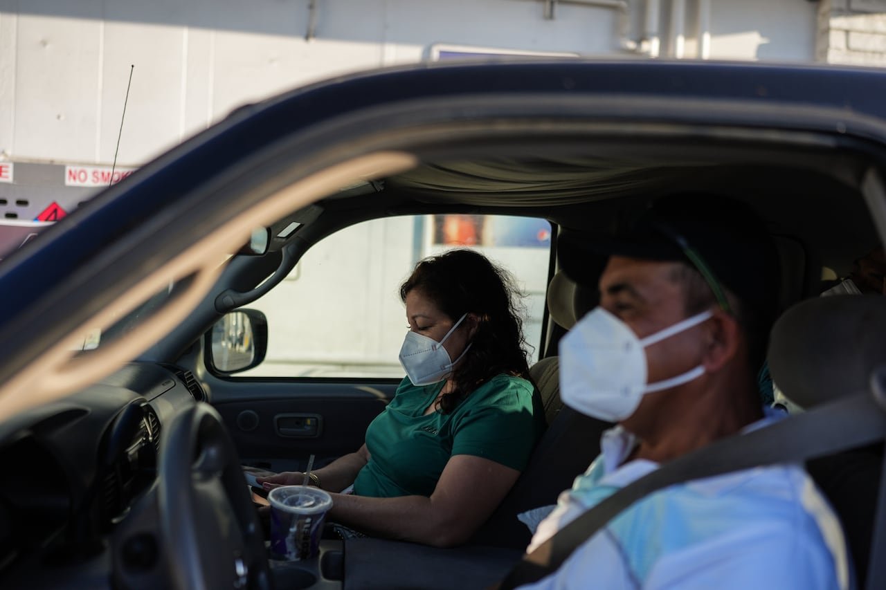 two masked evacuees sitting inside vehicle