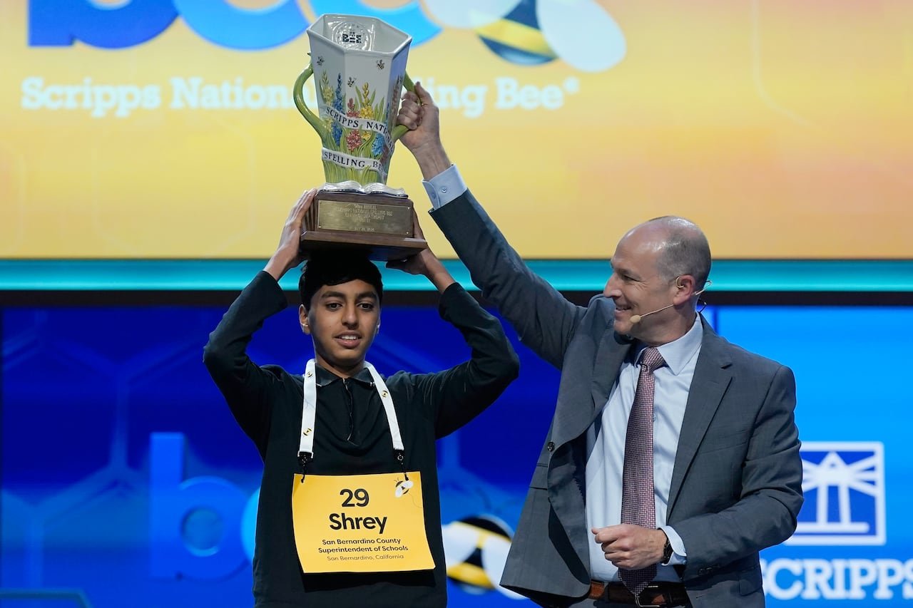 Young boy holding trophy triumphantly
