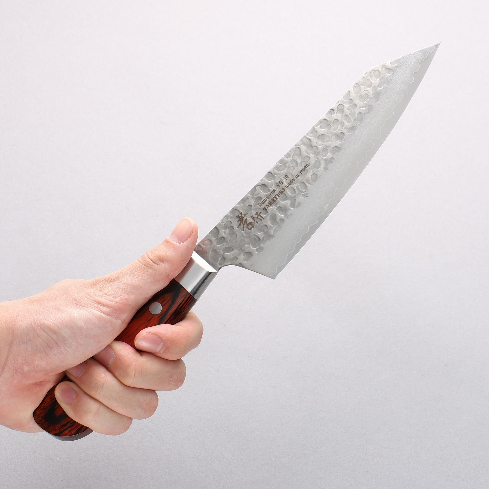 Compact Japanese kiritsuke style kitchen knife on wooden surface