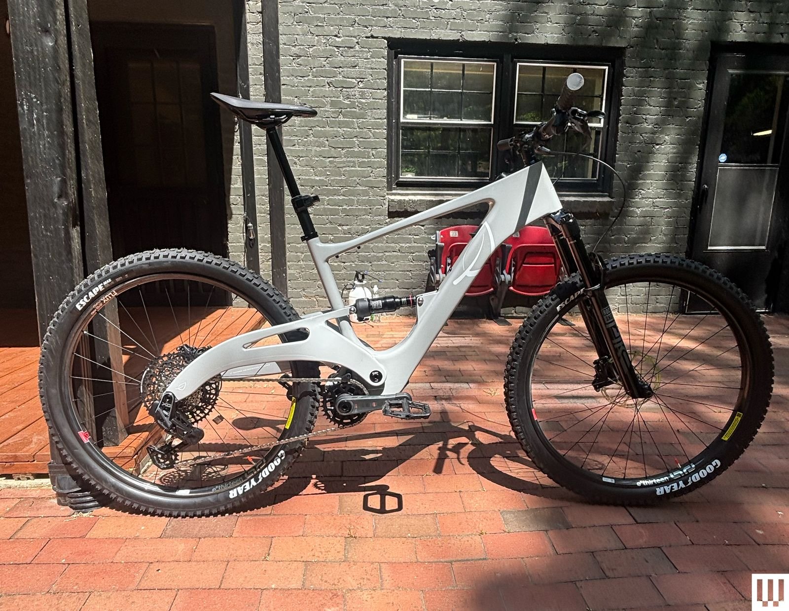 Modern black-and-white electric mountain bike parked near urban housing
