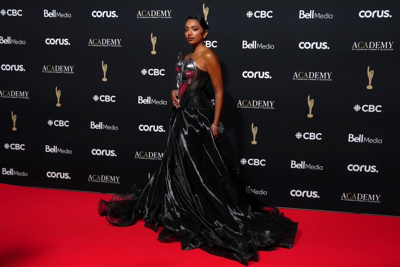 Nadine Bhabha wearing an elegant black strapless gown accented with silver and red details.