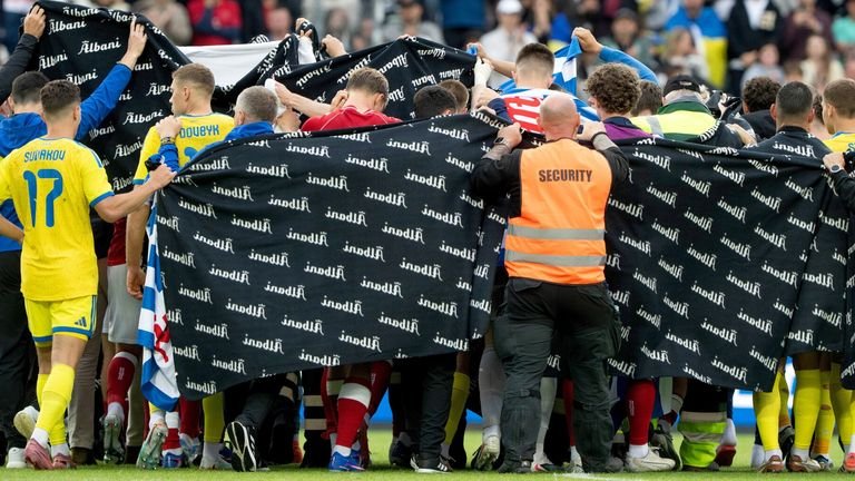 Players forming protective ring around injured christian Eriksen receiving treatment