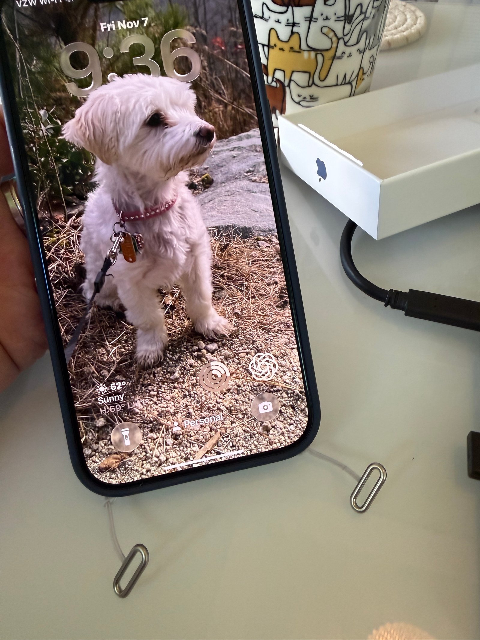 iPhone hanging from Apple crossbody