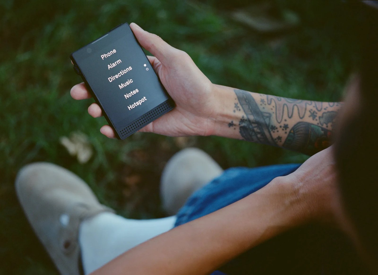 User holding minimalist Light Phone III device designed for distraction-free communication.